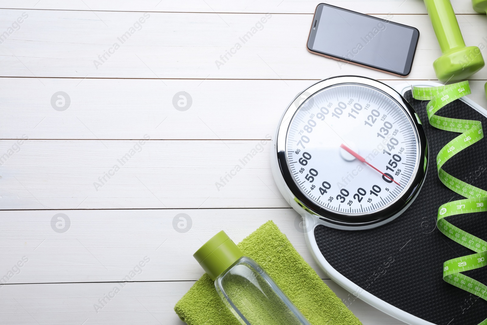 Photo of Flat lay composition with bathroom scale and measuring tape on white wooden floor, space for text. Weight loss concept