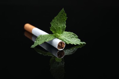 Photo of Menthol cigarette and mint on black background