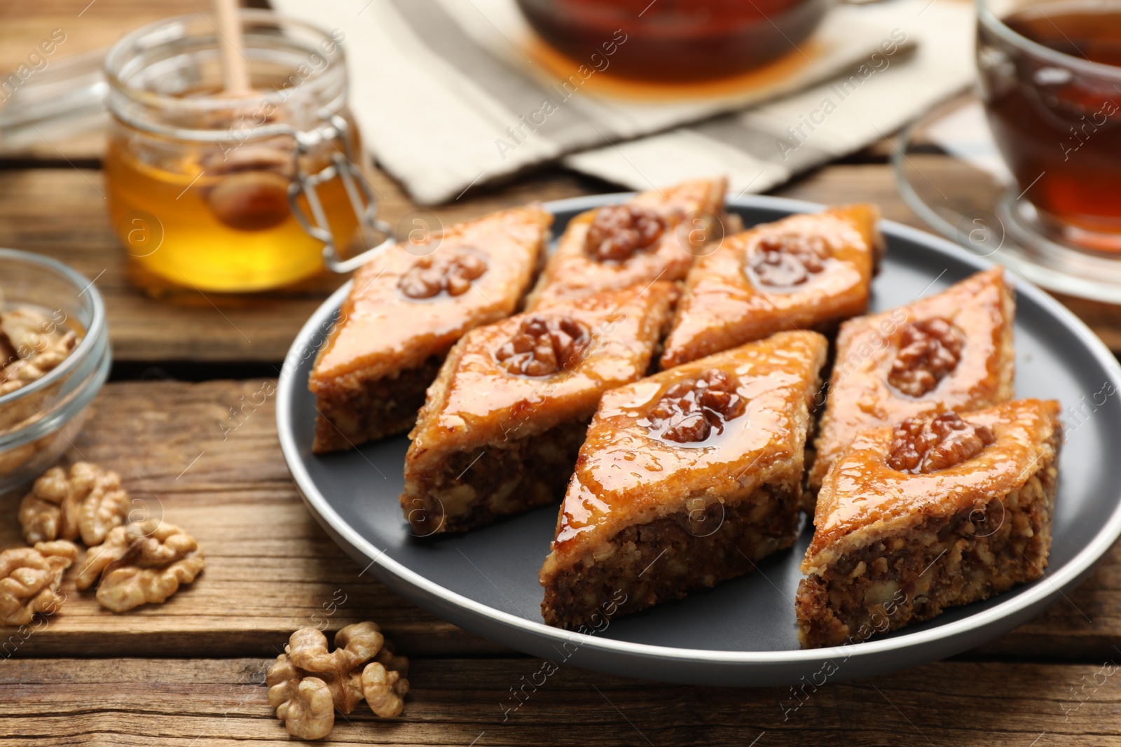 Photo of Delicious sweet baklava with walnuts on wooden table, closeup