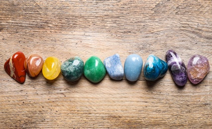 Flat lay composition with different gemstones on wooden table