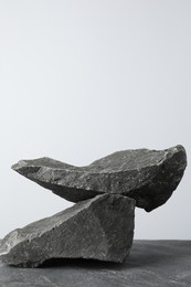 Photo of Presentation for product. Podium made of stones on grey table. Space for text