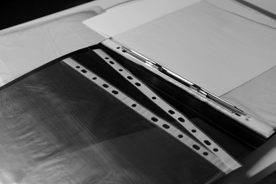 Folders with punched pockets on white table, closeup