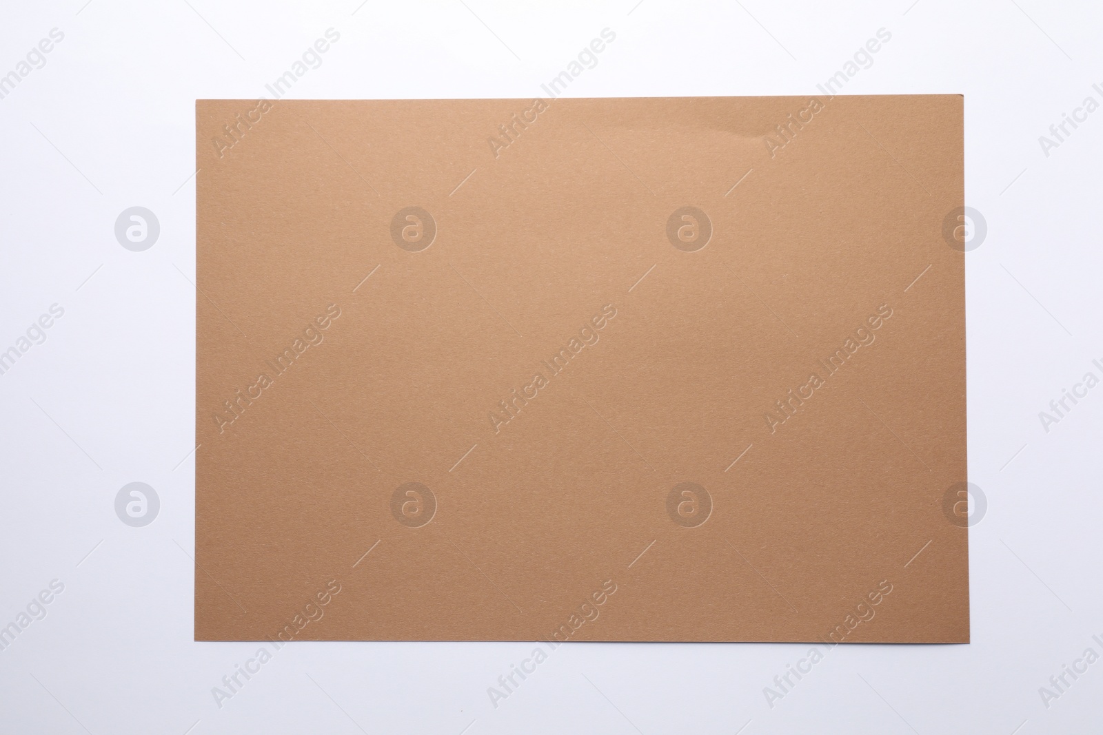 Photo of Empty kraft paper sheet isolated on white, top view