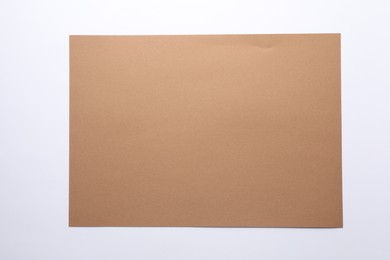 Photo of Empty kraft paper sheet isolated on white, top view