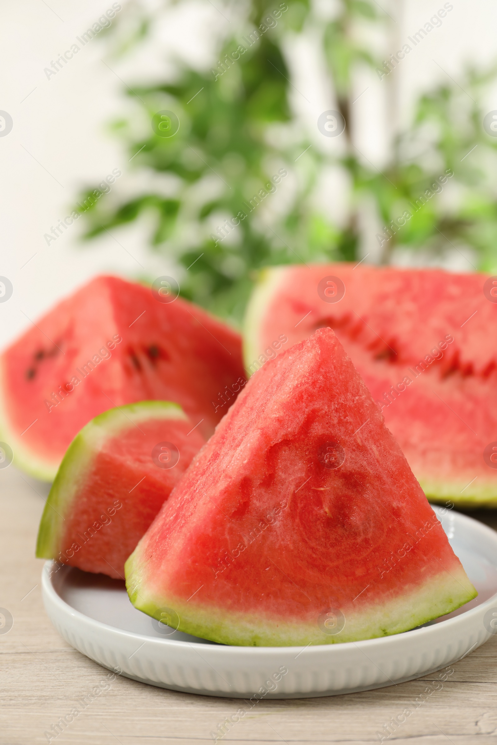 Photo of Slices of tasty ripe watermelon on light wooden table, space for text