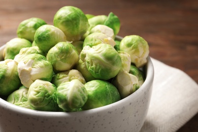 Photo of Bowl of fresh Brussels sprouts on table, closeup. Space for text