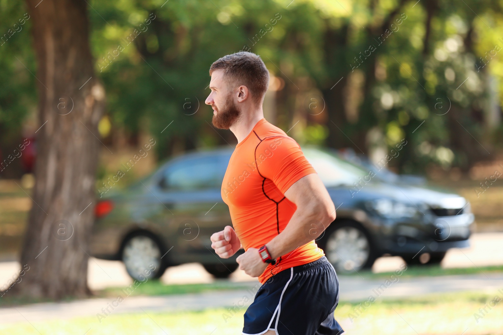 Photo of Young man running in park on sunny day