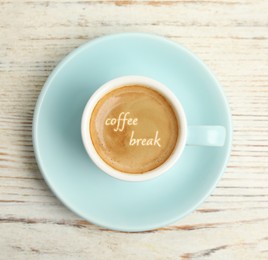 Image of Cup of aromatic espresso with phrase Coffee Break on white wooden table, top view  