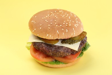 Photo of Burger with delicious patty on yellow background, closeup