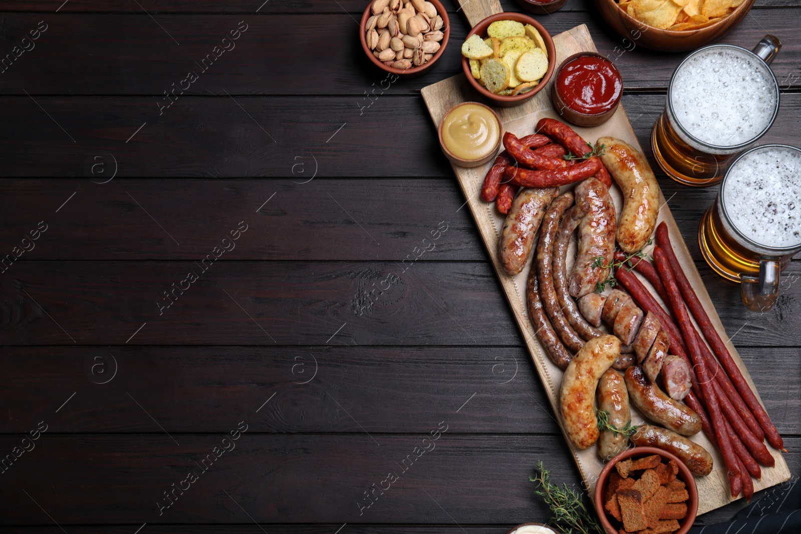 Photo of Set of different tasty snacks and beer on wooden table, flat lay. Space for text