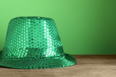 Photo of Green leprechaun hat on wooden table, space for text. St. Patrick's Day celebration