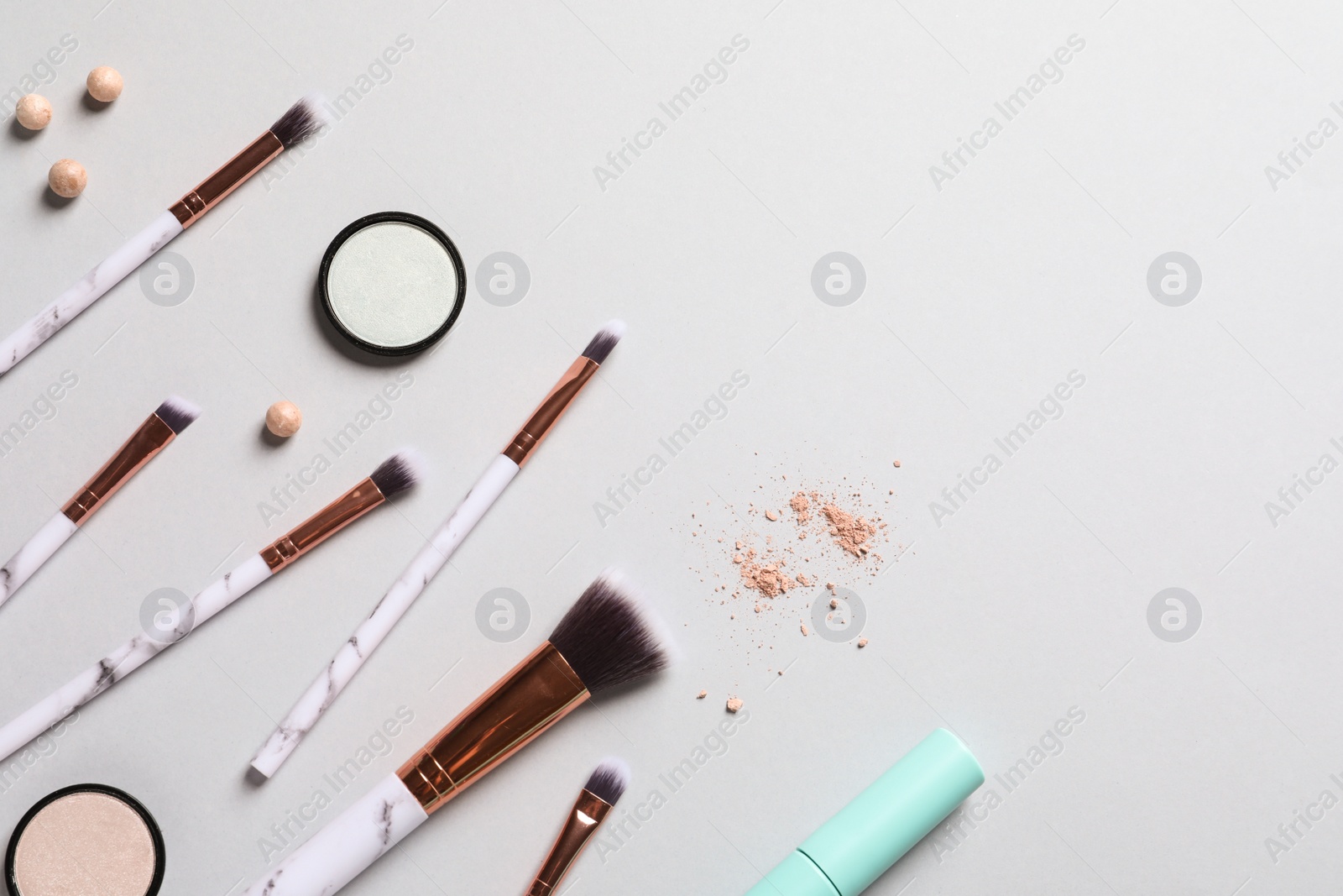 Photo of Flat lay composition with makeup brushes on grey background. Space for text