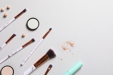 Flat lay composition with makeup brushes on grey background. Space for text