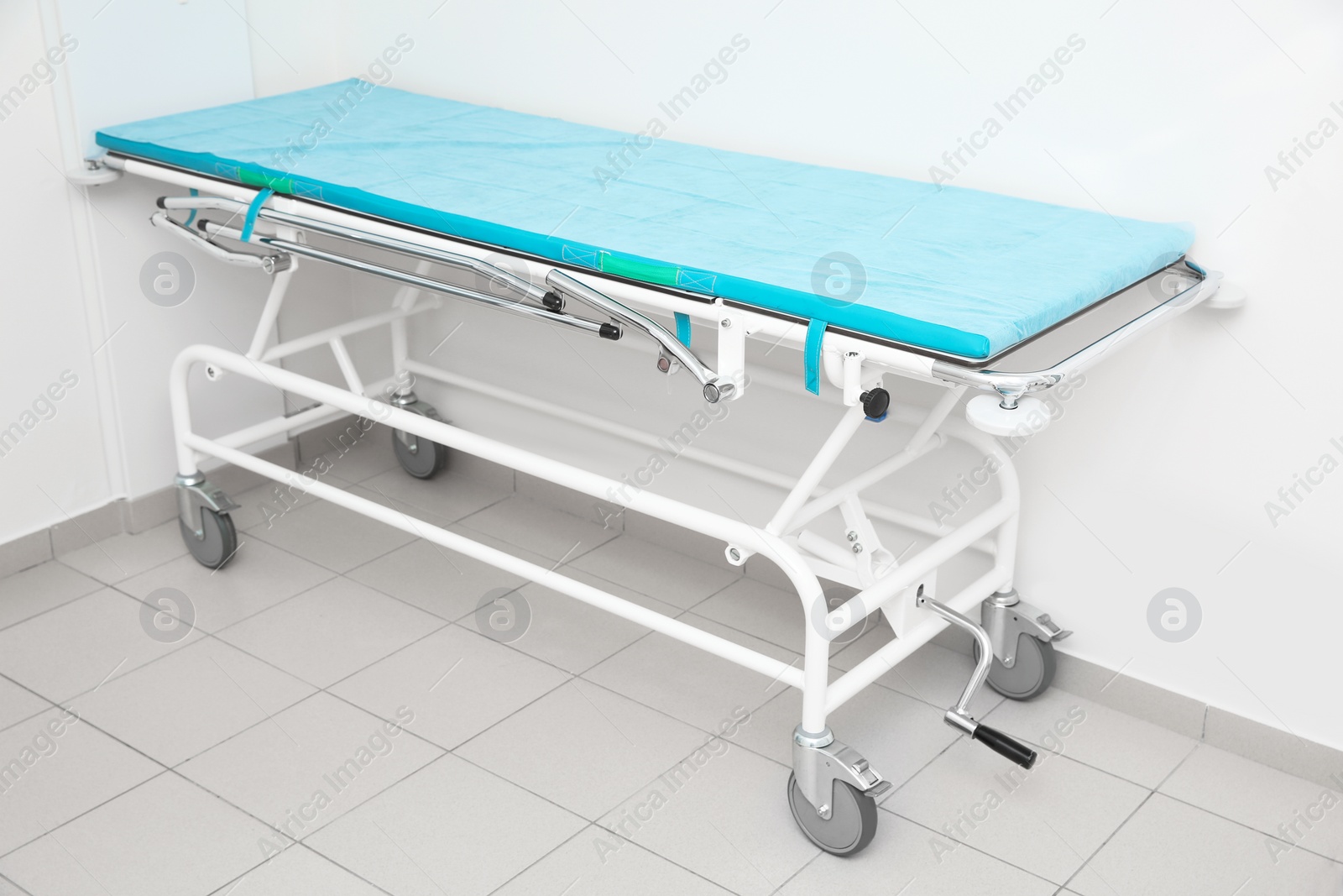 Photo of Medical trolley bed near wall in modern clinic