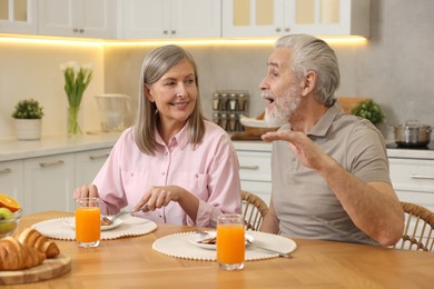 Photo of Happy senior couple having breakfast at home