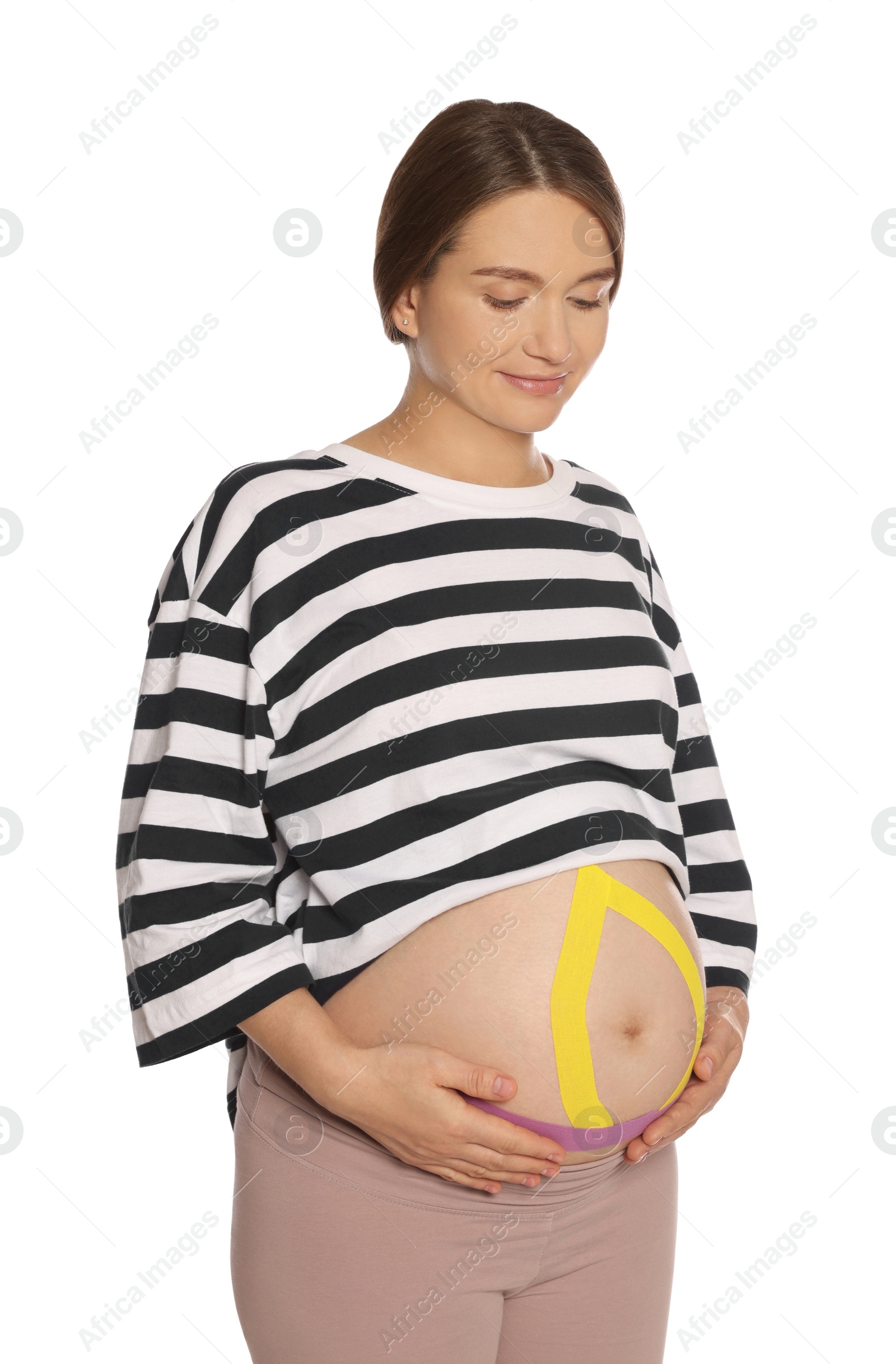 Photo of Pregnant woman with kinesio tapes on her belly against white background