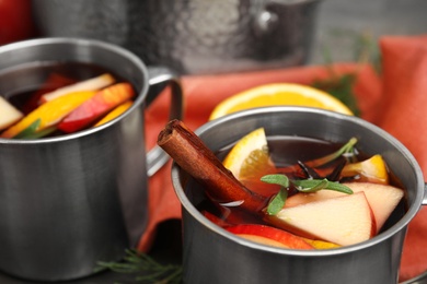 Tasty mulled wine with spices on table, closeup