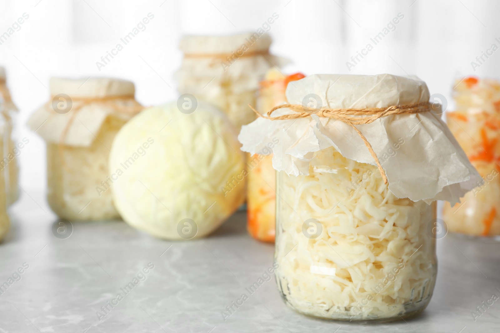 Photo of Tasty homemade fermented cabbage on light grey marble table