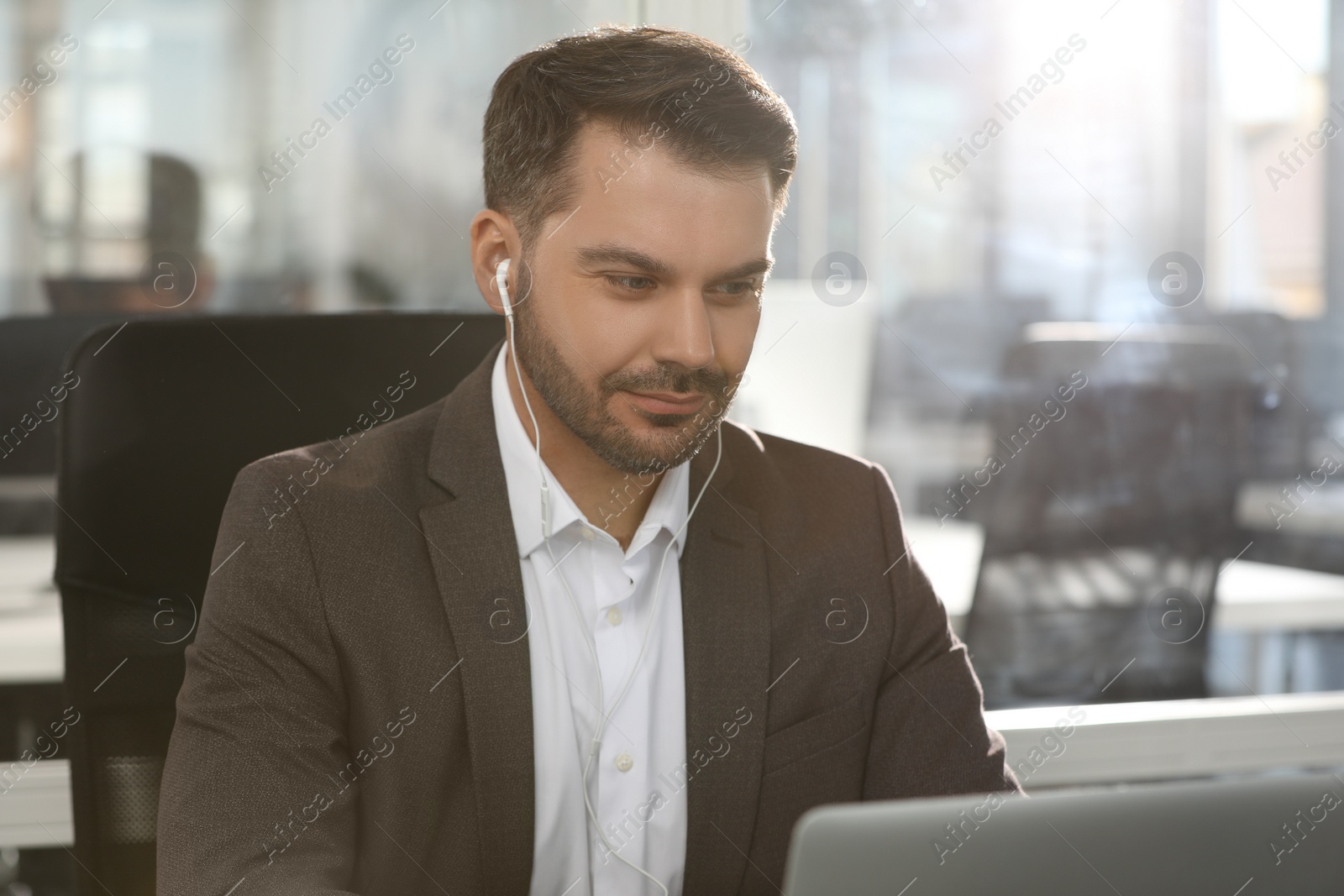 Photo of Man with earphones at workplace in office