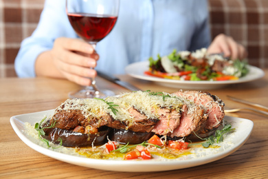 Photo of Delicious roasted meat and blurred woman on background