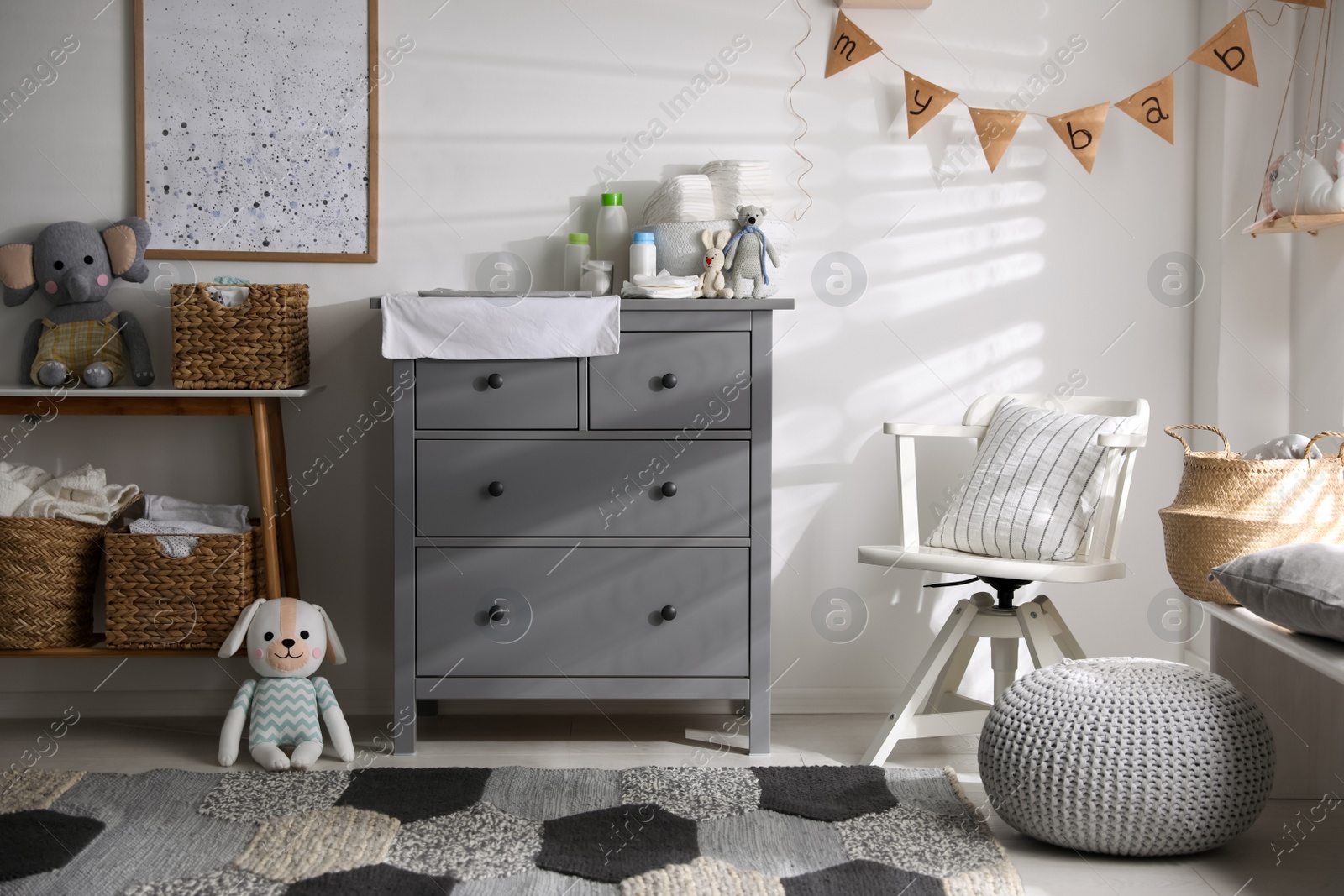 Photo of Chest of drawers with changing place in baby room. Interior design