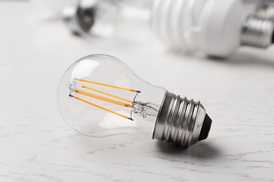 Photo of Vintage filament lamp bulb on white wooden table