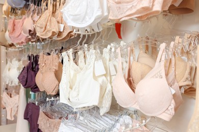 Photo of Many different beautiful women's underwear in lingerie store, closeup