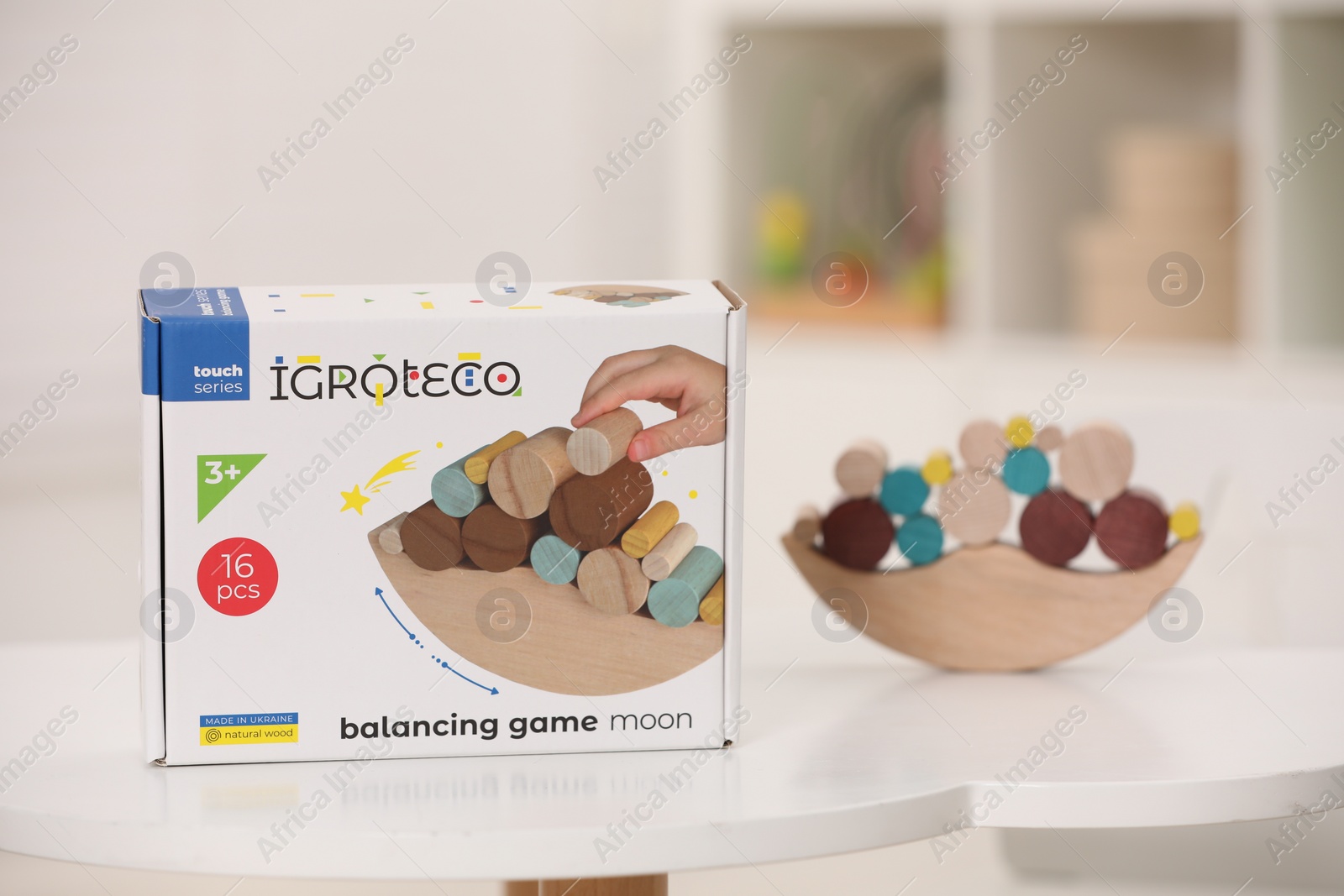 Photo of Wooden pieces of balancing game on white table indoors, space for text. Educational toy for motor skills development