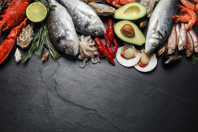 Photo of Fresh fish and different seafood on black table, flat lay. Space for text