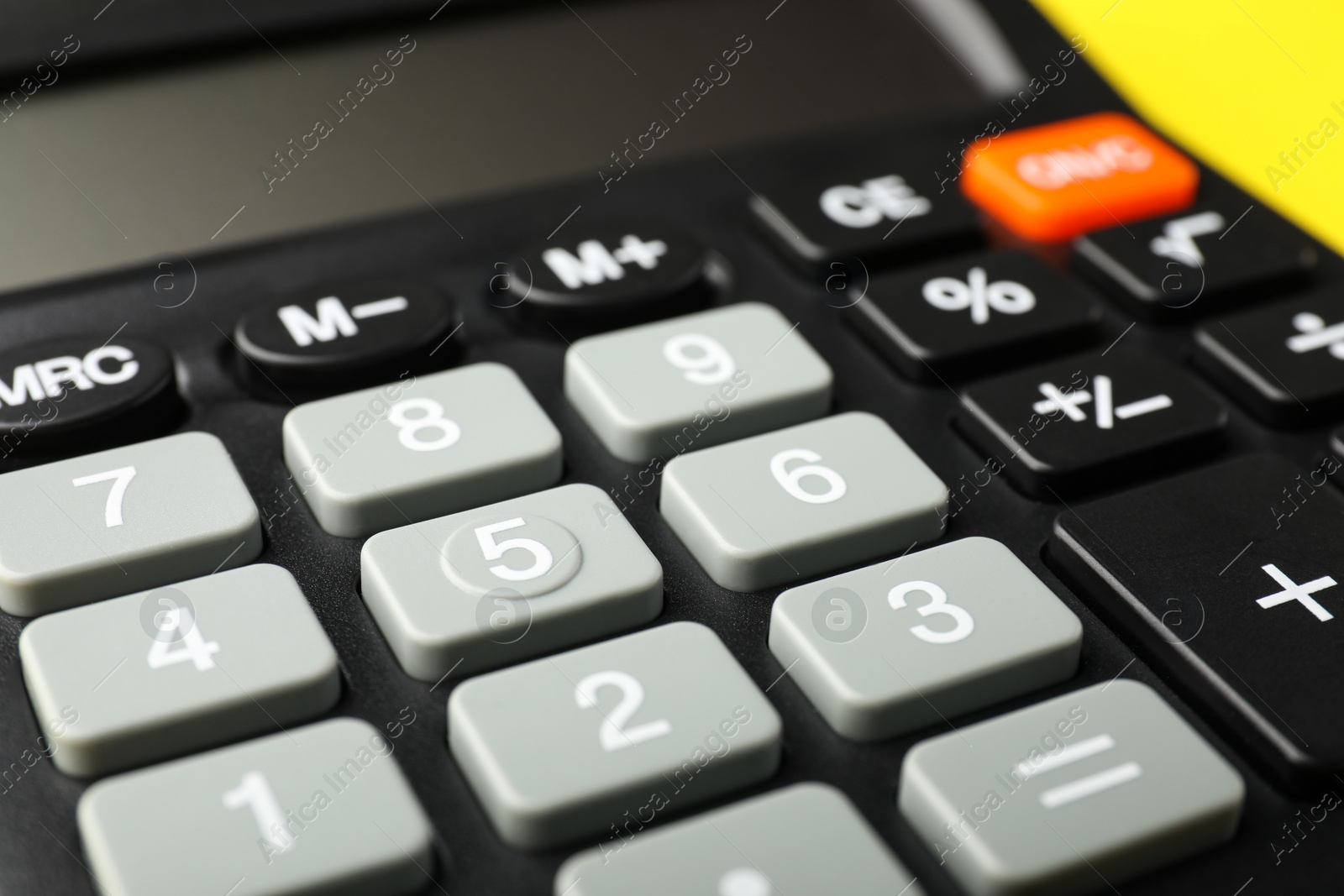 Photo of Calculator on yellow background, closeup. Office equipment