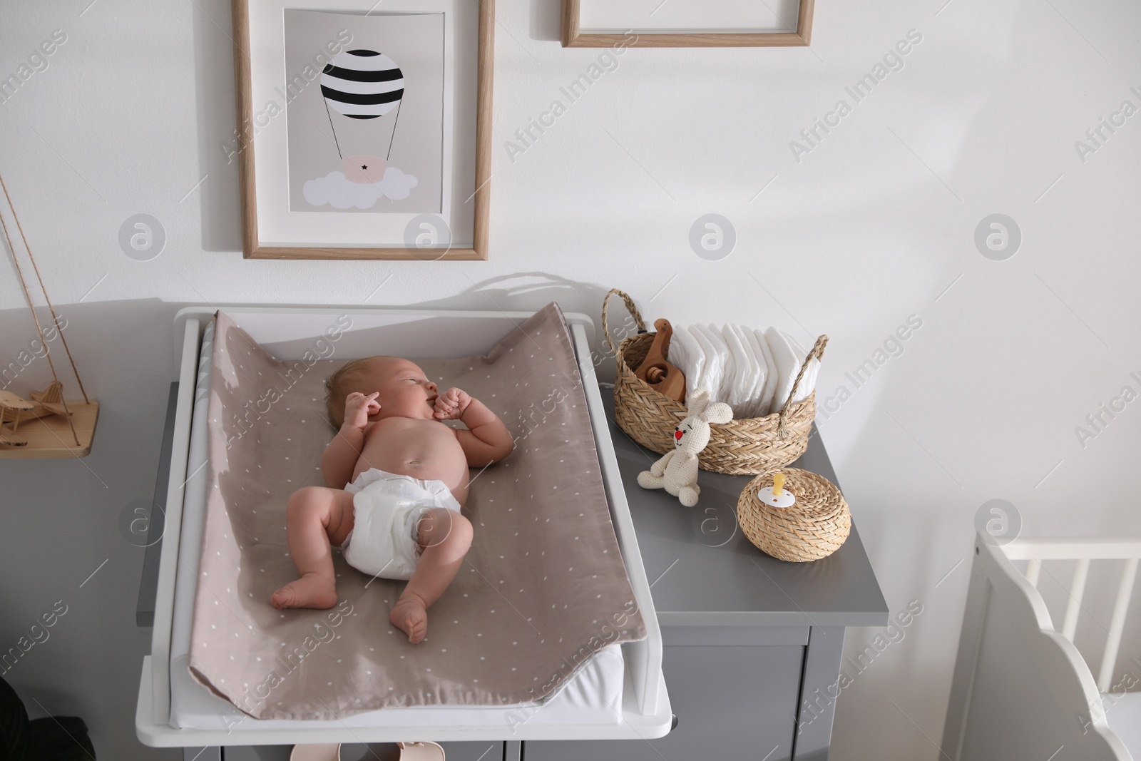 Photo of Cute little baby on changing table in room