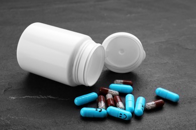 Photo of Antidepressants with happy emoticons and medical jar on black background