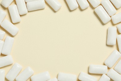 Photo of Frame made of tasty white chewing gums on beige background, flat lay. Space for text