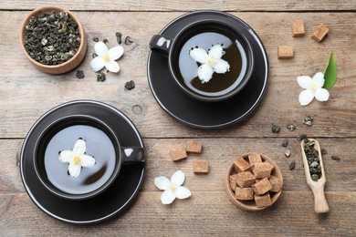 Photo of Flat lay composition with tea and fresh jasmine flowers on wooden table