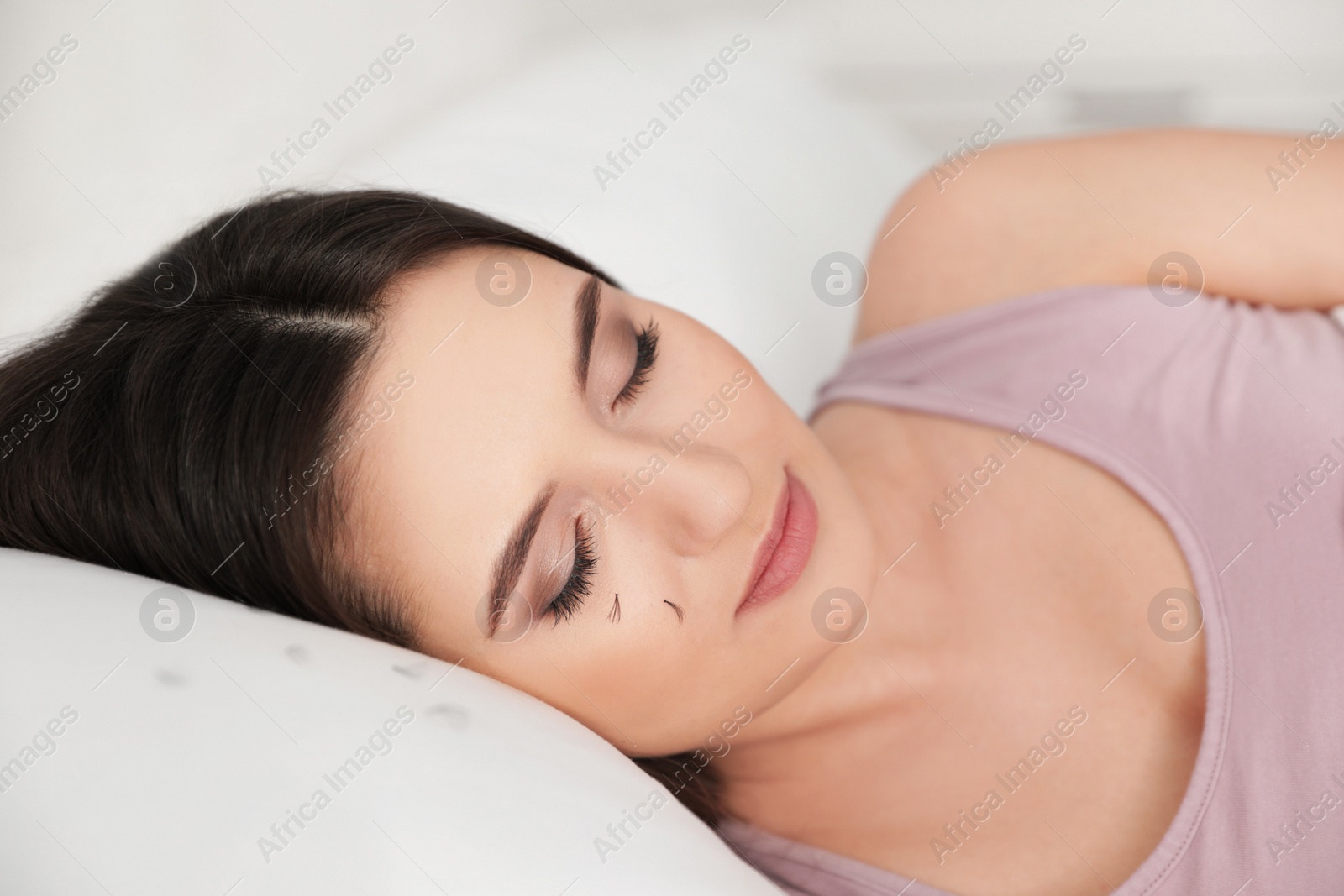 Photo of Young woman with eyelash loss problem sleeping in bed