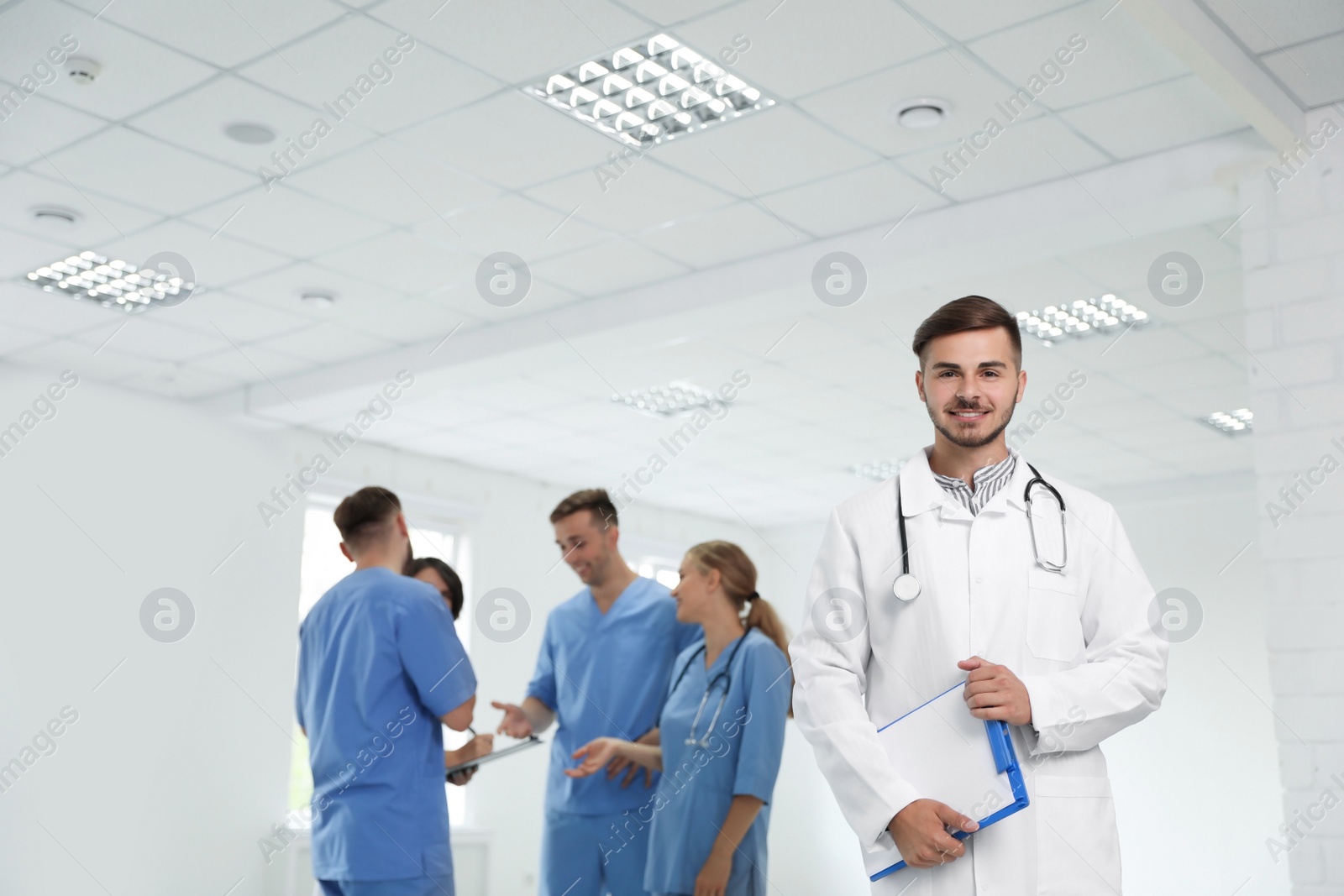 Photo of Portrait of male doctor and his colleagues at workplace