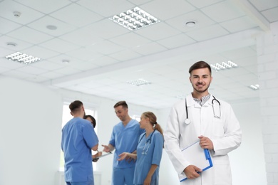 Portrait of male doctor and his colleagues at workplace