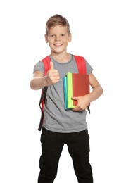Photo of Cute boy with school stationery showing thumb up on white background