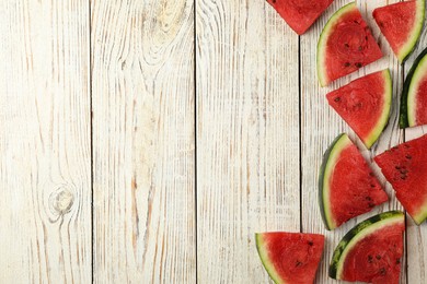 Photo of Slices of delicious ripe watermelon on white wooden table, flat lay. Space for text