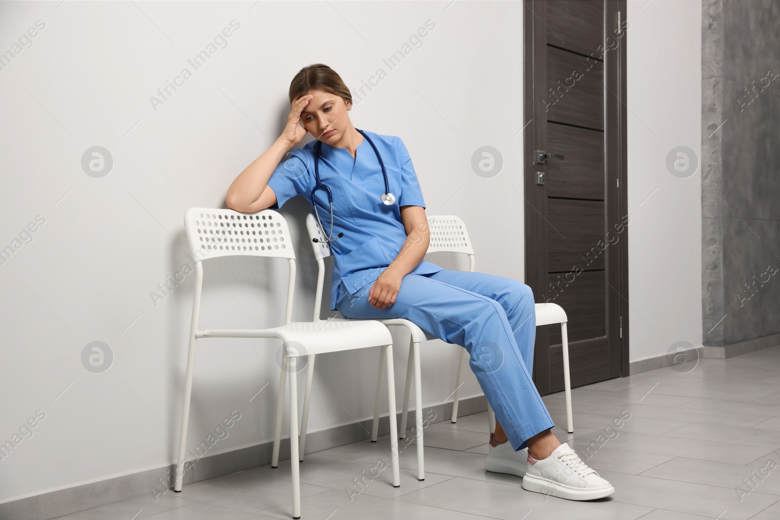 Photo of Exhausted doctor resting on chair in hospital