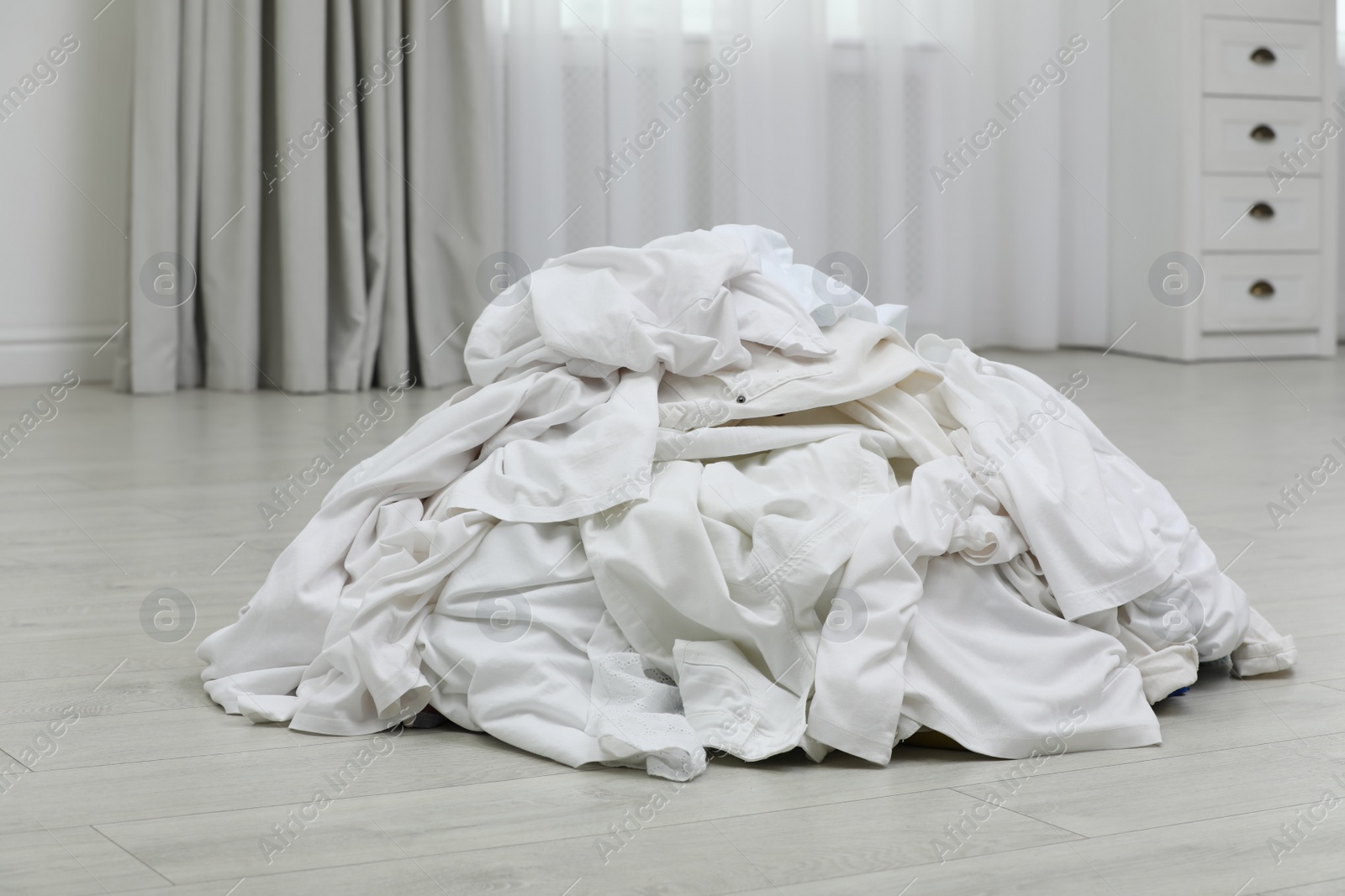 Photo of Pile of dirty laundry on floor indoors