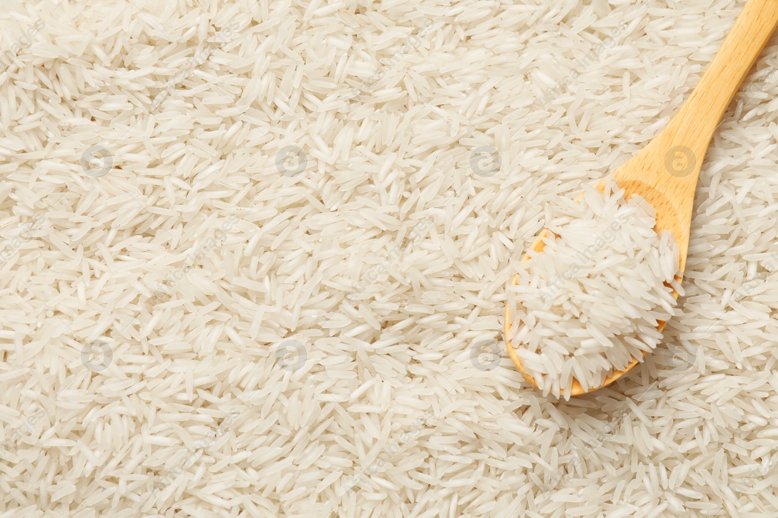 Photo of Raw basmati rice and spoon as background, top view