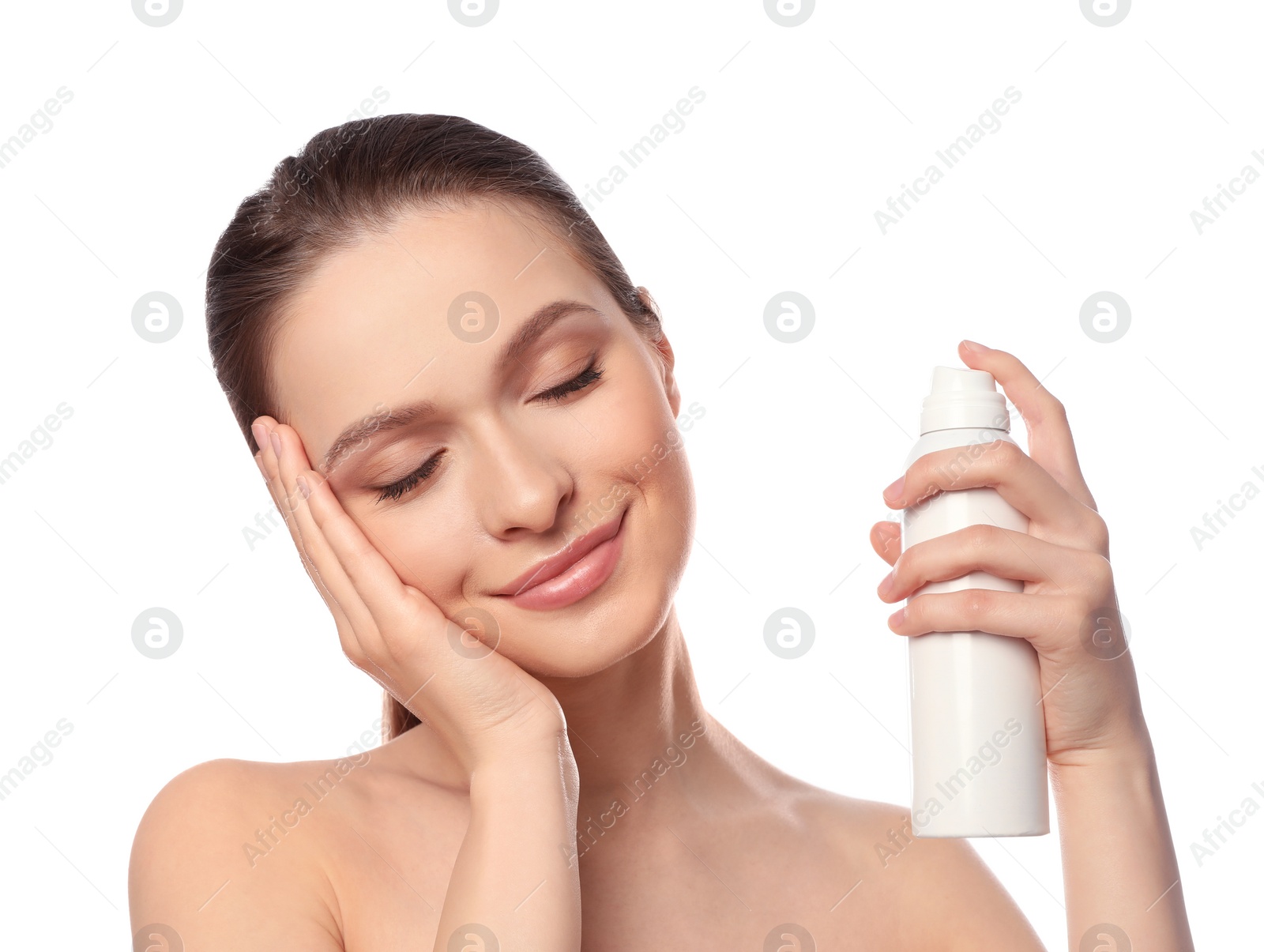 Photo of Young woman applying thermal water on face against white background. Cosmetic product