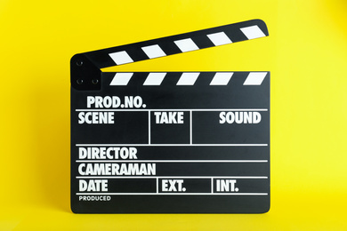 Photo of Clapper board on yellow background. Cinema production