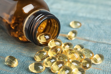 Photo of Bottle with cod liver oil pills on table, closeup