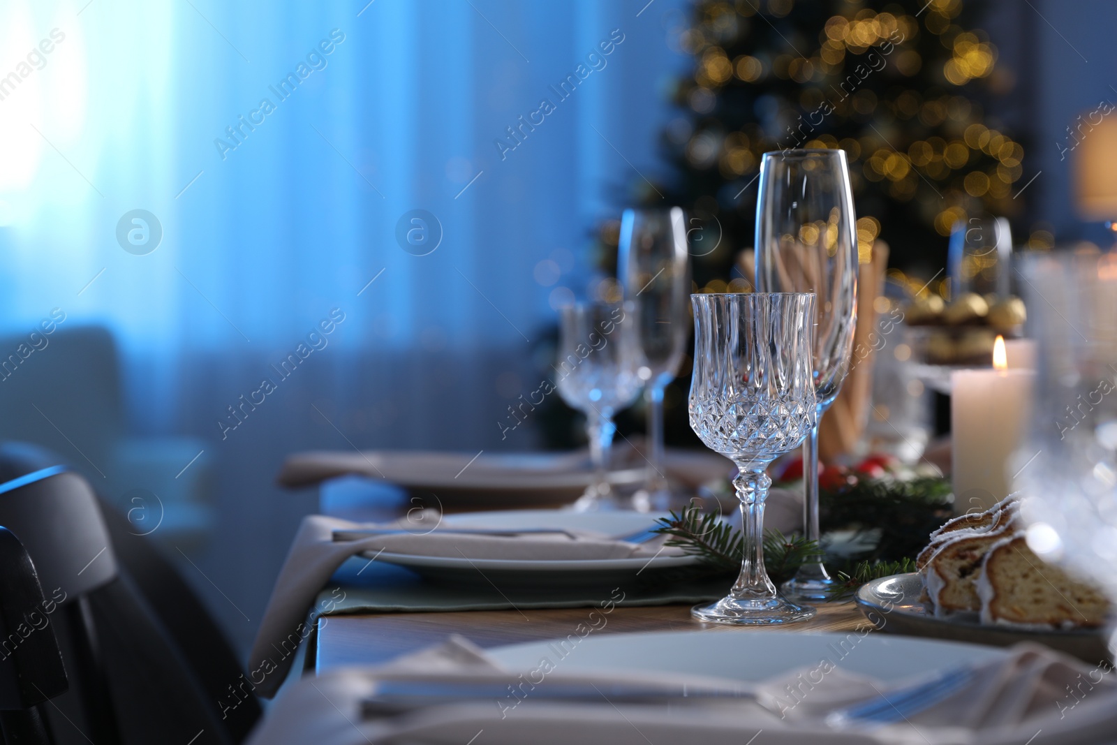 Photo of Christmas table setting with festive decor and dishware in room