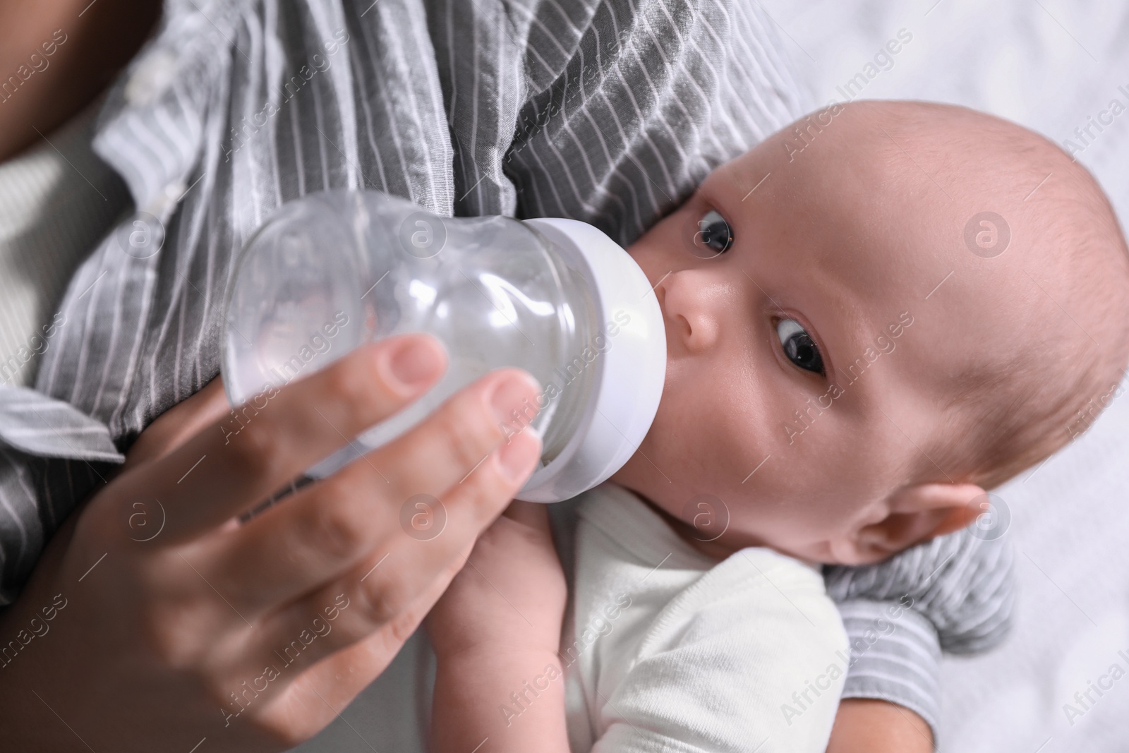 Photo of Mother feeding her little baby from bottle, closeup