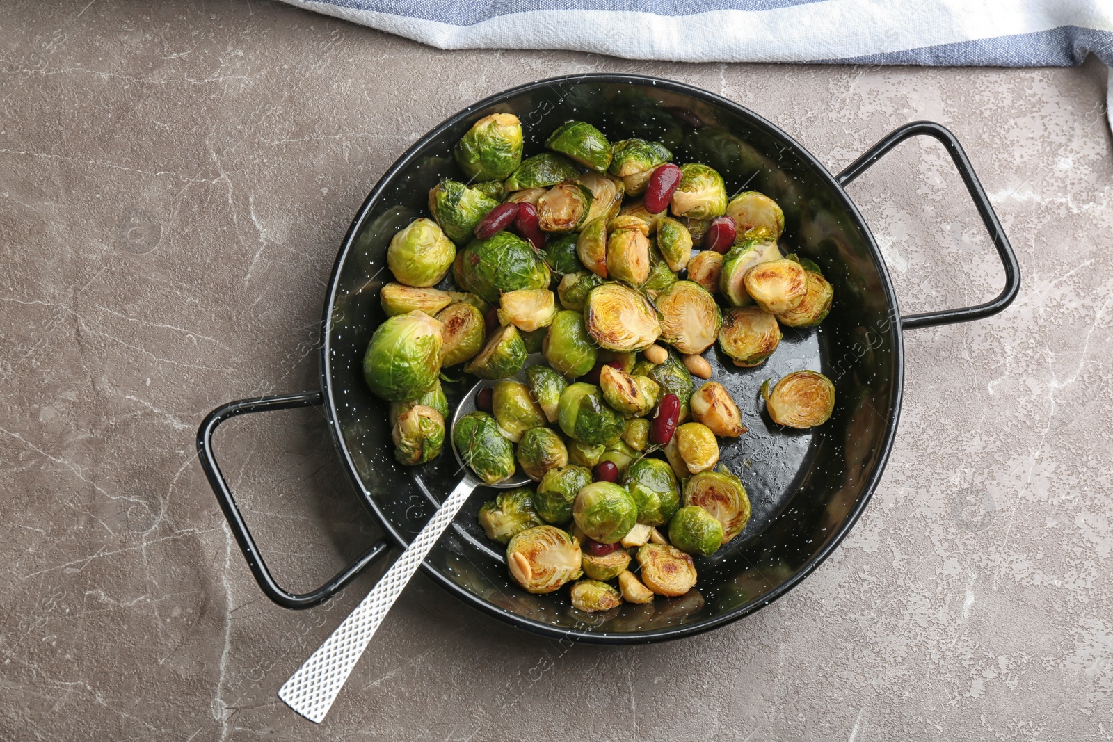 Photo of Delicious roasted brussels sprouts with red beans and peanuts on grey marble table, top view
