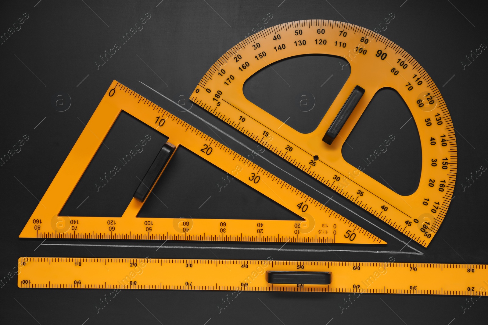 Photo of Triangle, protractor, ruler and drawn acute angle on black table, flat lay