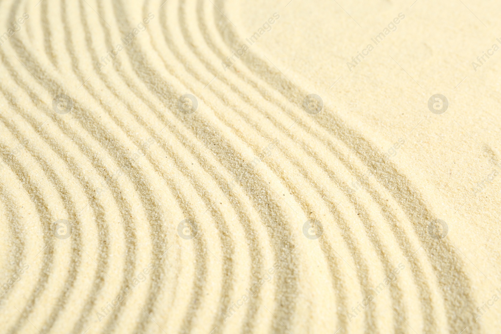 Photo of Zen rock garden. Wave pattern on beige sand